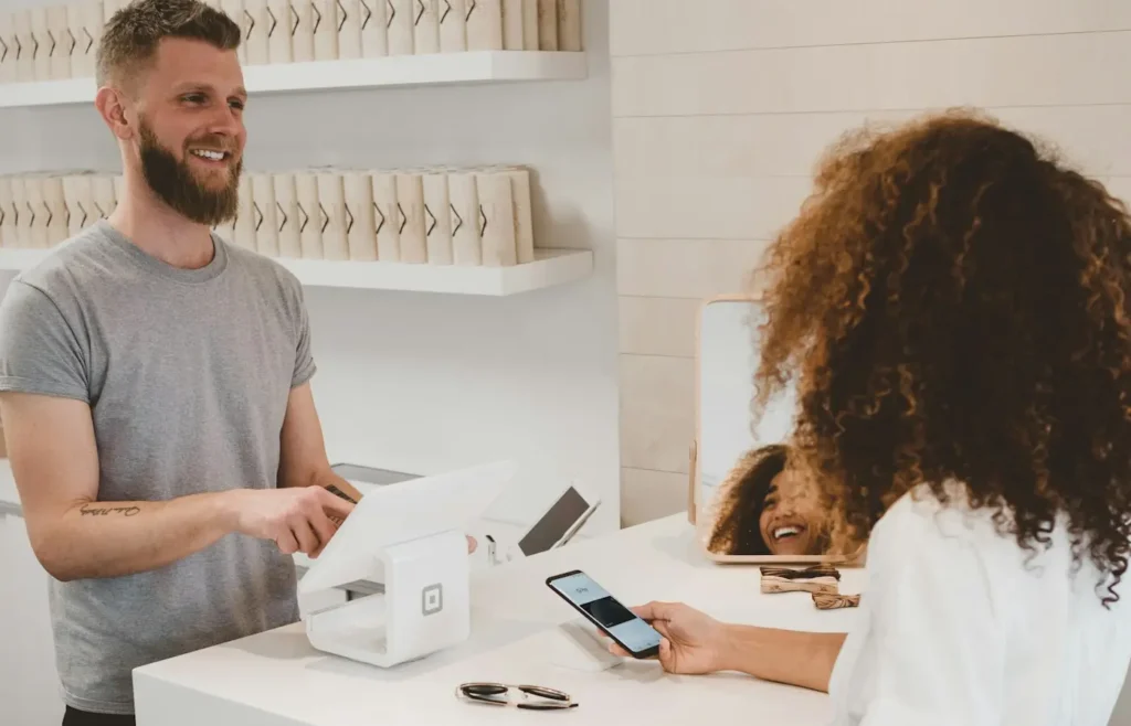 A customer paying at a shop counter with a phone
